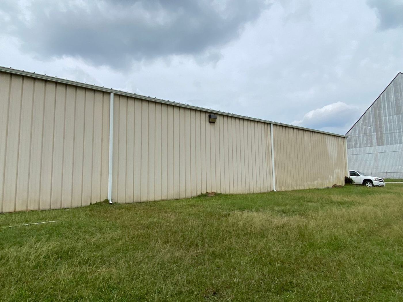 Warehouse siding washed clean by Make It Happen Pressure Washing